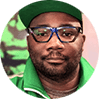 Circular image of Jason McKoy. He is wearing a baseball cap with a green brim, thick-rimmed glasses, and a green zip up jacket.